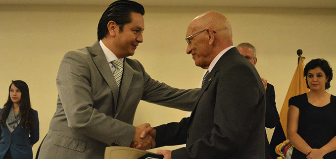 Padre Javier Herrán, rector de la UPS recibiendo la Presea  entregada por el Econ. Claudio Patiño, 2° vicepresidente de la Cámara de Industria, Producción y Empleo.