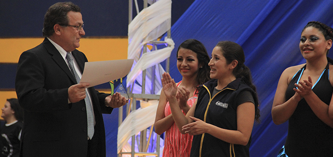 José Juncosa, vicerrector de sede Quito entregando premio a la instructora del grupo de Baile de Salón Johanna Franco