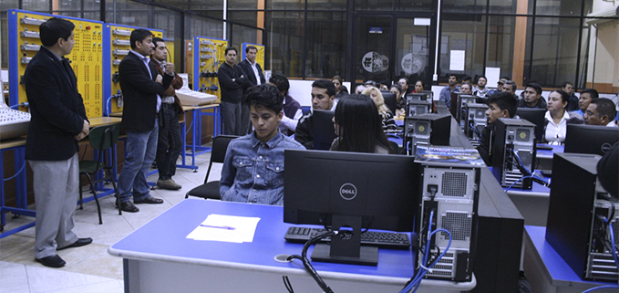 Jóvenes y padres de familia escuchando la explicación del Ph.D. Luis Garzón, director de la carrera de Ingeniería Mecánica.