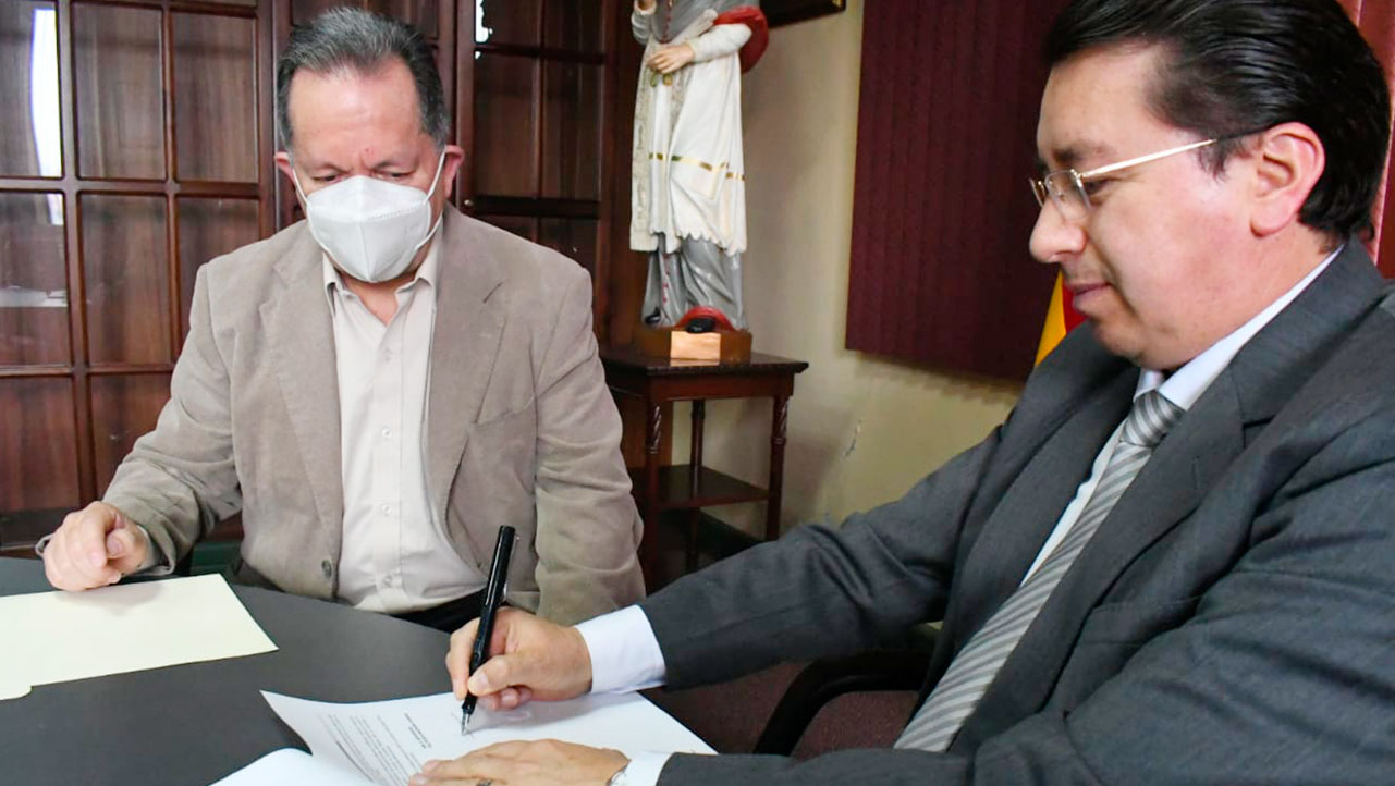Juan Cárdenas signing the agreement