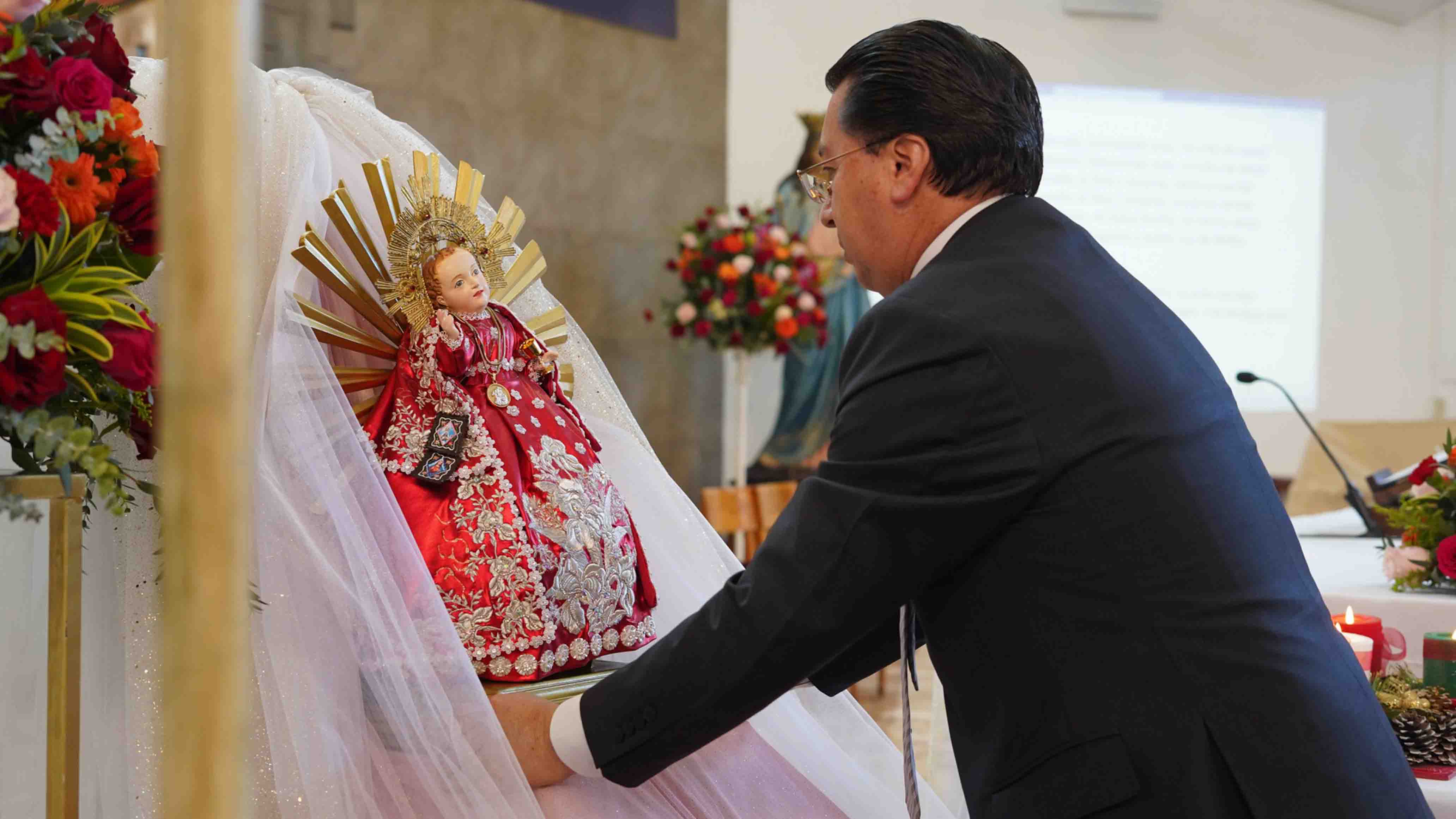 Padre Juan Cárdenas levantando al Niño Viajero en el Templo Universitario