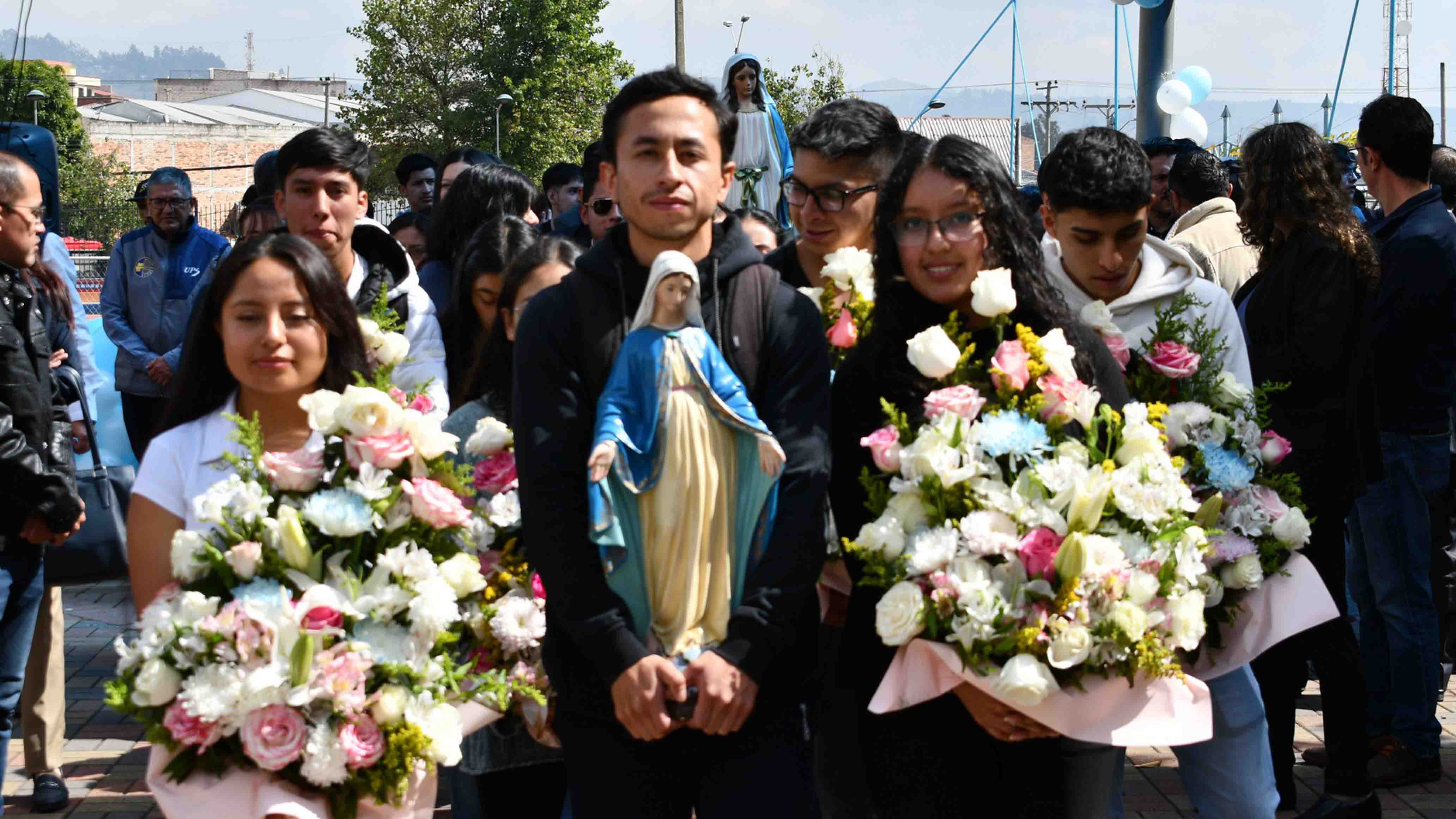 Estudiantes y colaboradores durante la procesion de la virgen