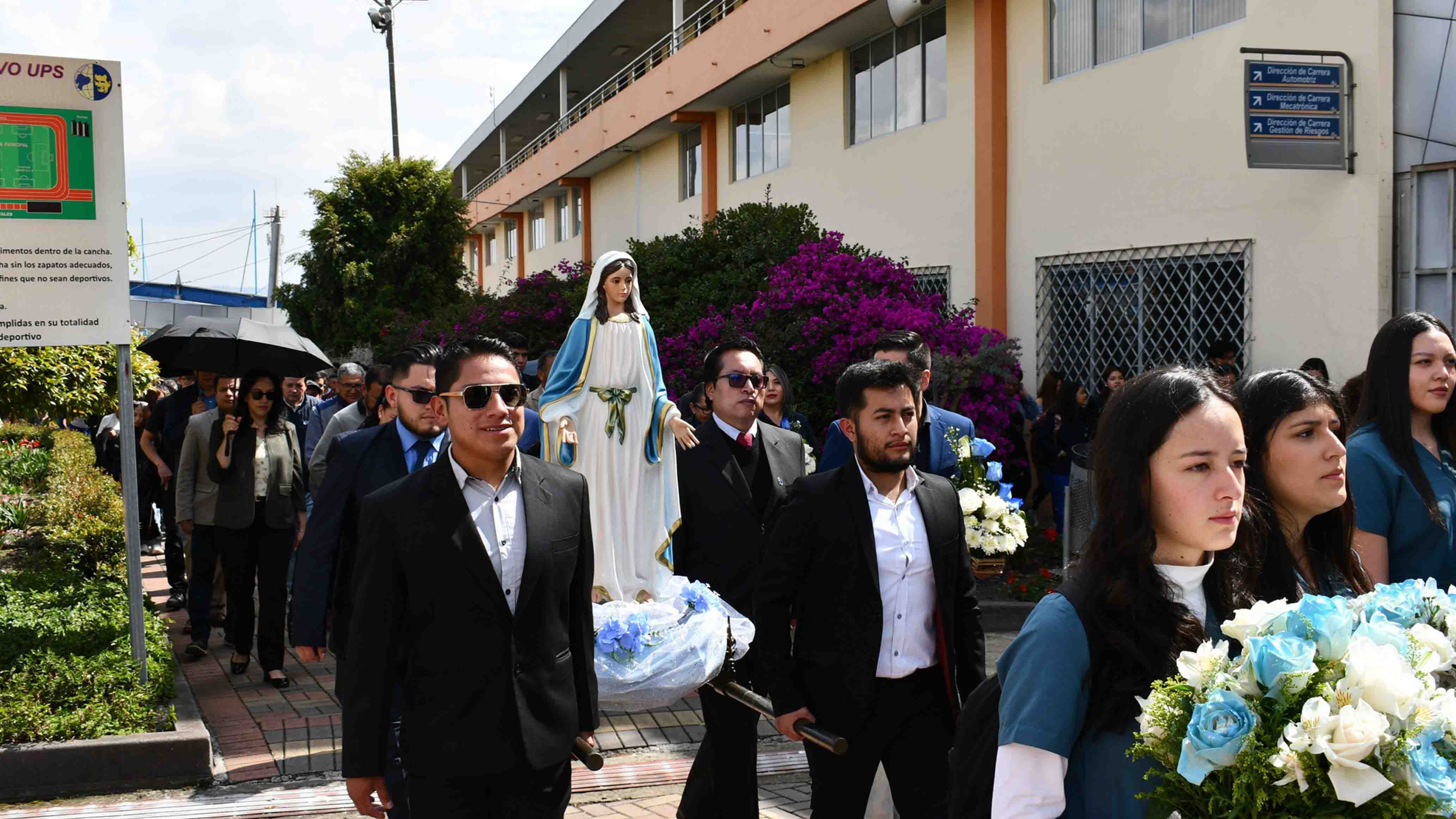 Colaboradores de la UPS durante la procesión llevando la imagen de la Virgen